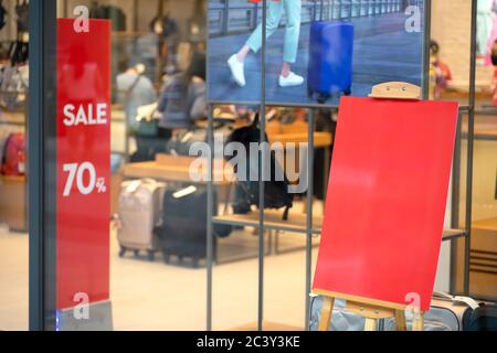 Mockup blank screen  signboard standing with  at bag and luggage shop, Mock up red screen empty space frame advertisement information board for insert Stock Photo