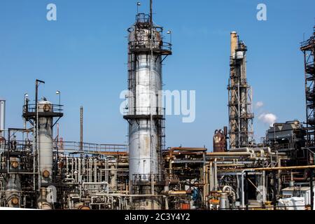 Petro chemical refinery pipes and cracking towers against a blue sky Stock Photo