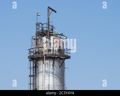 Petro chemical refinery pipes and cracking towers against a blue sky Stock Photo