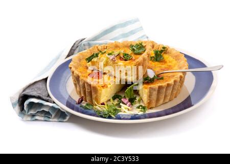 a cheese quiche with dried tomatoes with one piece cut out ready to serve isolated on white Stock Photo
