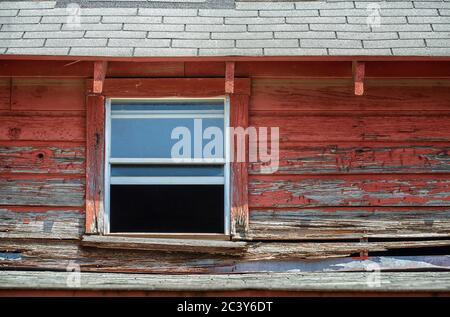 Window of an old abandoned and weathered red barn. Closeup. Stock Photo