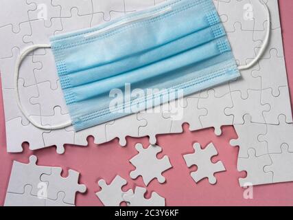 Surgical mask on white jigsaw puzzle Stock Photo
