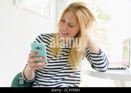 Smiling woman using smart phone Stock Photo