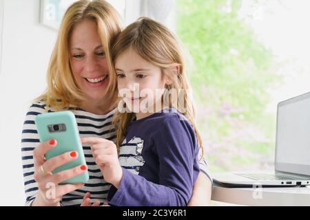 Mother and daughter (6-7) using smart phone Stock Photo