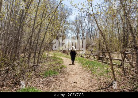 USA, Idaho, Bellevue, Senior woman walking along rural path Stock Photo