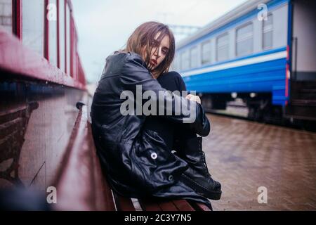 Belarus, Minsk, Young woman waiting on train platform in rain Stock Photo