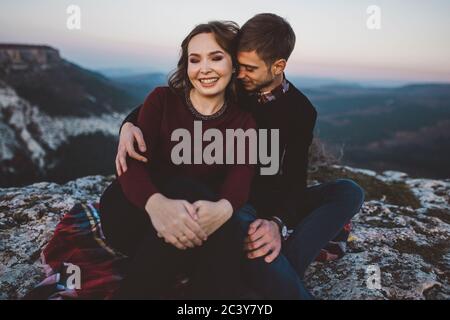 Ukraine, Crimea, Young couple sitting and hugging near canyon Stock Photo