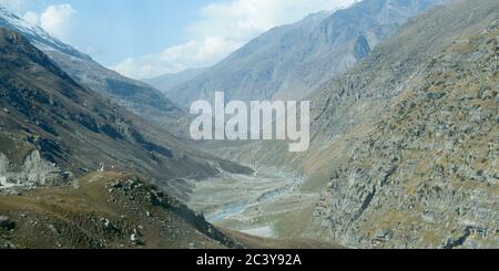 V-shaped Himalayas valley down which a river with a winding course flows. An interlocking overlapping spur hill ridges V-shaped valley that extends in Stock Photo