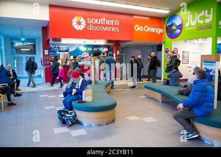 Milford Sound, Fiordland, New Zealand, June 20 2020: Tourists line up to get their picnic lunch and boarding passes to go out on a cruise of the sound Stock Photo