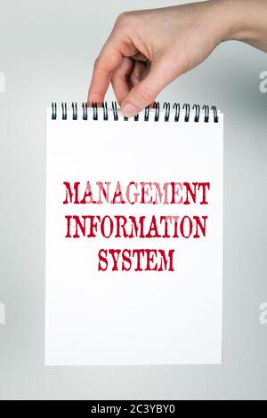 MANAGEMENT INFORMATION SYSTEM concept. Note book with text in the hand Stock Photo