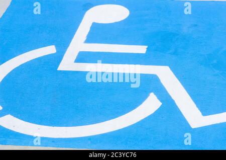 Close up detail of white on blue Handicapped in wheelchair sign and symbol on disabled car park Stock Photo