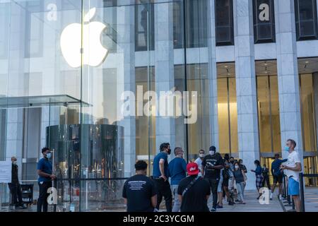 NEW YORK, NY - JUNE 22, 2020: People stand in a socially distanced line outside the Apple Store on Fifth Avenue. Stock Photo