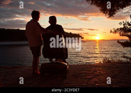 Senior couple standing on the Adriatic seashore during sunset Stock Photo
