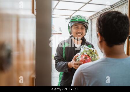 portrait of asian delivery man delivering fruit parcel Stock Photo