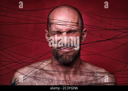 Photo of tangled in black threads adult man Stock Photo
