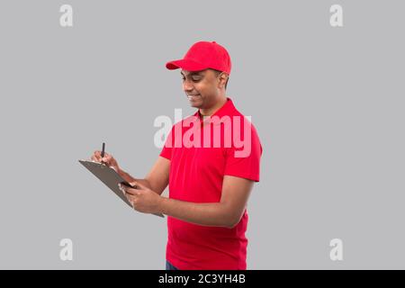 Delivery Man Writing in clipboard. Indian Delivery Boy Clipboard Stock Photo