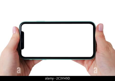 Moscow, Russia - January 18, 2020: Green Apple iPhone 11 mock up horizontal in a female hands isolated on a white background. Close-up of a new smartp Stock Photo