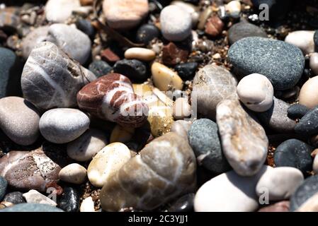Colour different stones and pebbles on the seaside sand Stock Photo