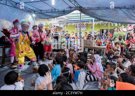 Jakarta, Indonesia. 22nd June, 2020. The Community “Aku Badut Indonesia” (I am Indonesian Clown) entertains a number of children affected by the fire in the settlement in Jakarta, Indonesia, June 23, 2020. The activity is aimed at trauma healing and a form of caring for Jakarta fires victims especially children. (Photo by Evan Praditya/INA Photo Agency/Sipa USA) Credit: Sipa USA/Alamy Live News Stock Photo