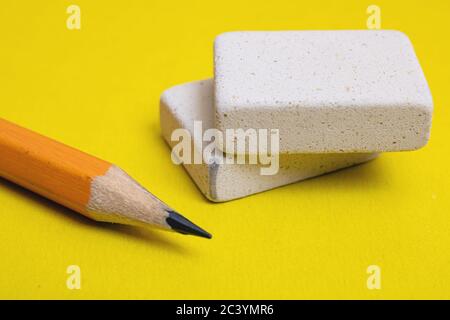Two erasers and pencil on a yellow background Stock Photo