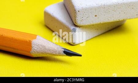 Two erasers and pencil on a yellow background Stock Photo