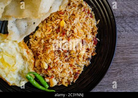 Spicy fried rice with dried chilli with fried egg and fish cracker.