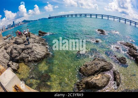 Black stone and city cross-sea bridge in the sea in Dalian, Liaoning, China in the morning Stock Photo