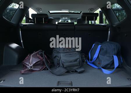 Three bags are in the trunk of an SUV. Travel Fees Stock Photo