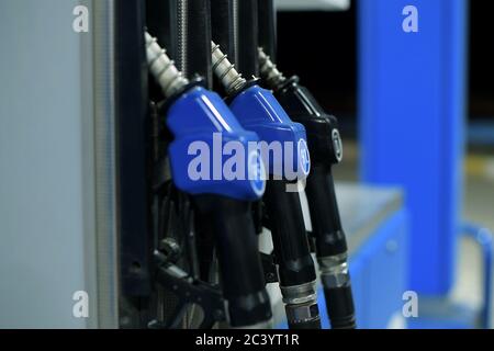 refueling guns hang at a gas station in the evening Stock Photo