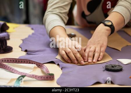 Tailor woman is working at table in atelier Stock Photo