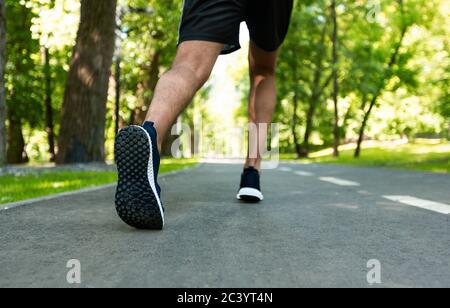 Cropped view of marathon runner on his morning training at city park, closeup Stock Photo
