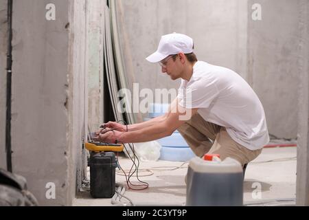 Electrician checks the voltage in the mains Stock Photo