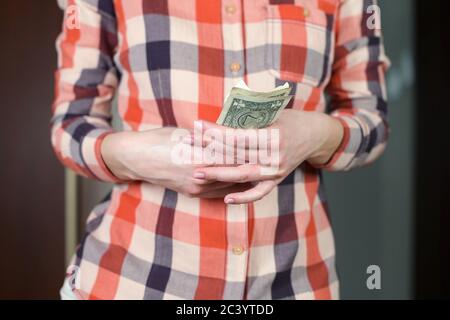 woman recounts savings in a difficult moment, straightening crumpled dollars Stock Photo