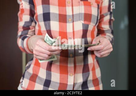 girl straightens wrinkled dollar bills and folds together Stock Photo