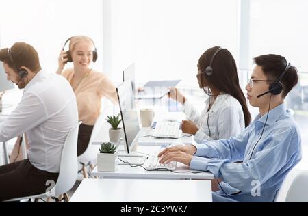 Team of technical support agents working on hotline at call center Stock Photo