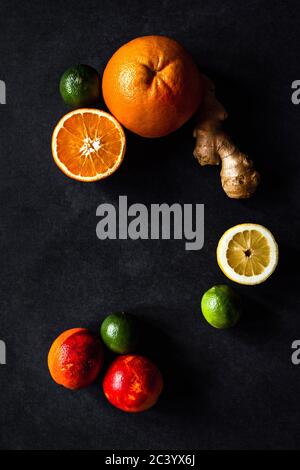 Top view photo of fruits, grapefruit, orange, lemon, lime, blood oranges and ginger. Dark and moody photo, on a grey background. Copy space. Stock Photo