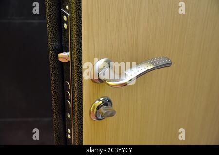 Modern style doorknob on a wooden door. Door lock Stock Photo