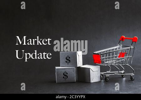 Shopping cart with words MARKET UPDATE on dark background. Business, Copy space and online shopping concept. Selective focus Stock Photo