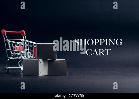 SHOPPING CART text with shopping cart on dark background. Business, Copy space and online shopping concept. Selective focus Stock Photo