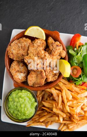 Ray cheeks, also known as skate knobs, from thornback rays, Raja clavata, that have been coated in breadcrumbs and oven cooked. Served with homemade c Stock Photo