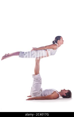 Couple practicing acro yoga against white background Stock Photo