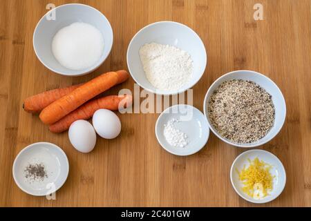 Baking ingredients for an Easter carrot cake on a wooden kitchen board, high angle view from above, selected focus Stock Photo