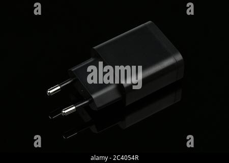 Socket travel charger for USB port output on black mirror background. High resolution photo. Full depth of field. Stock Photo