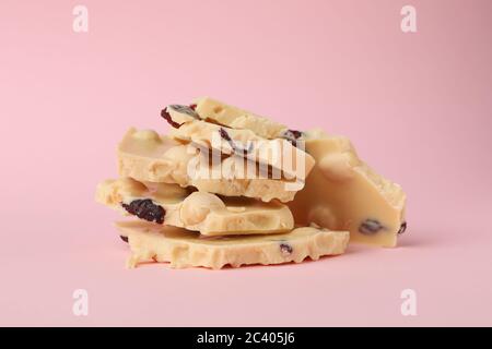 White chocolate pieces on pink background. Sweet food Stock Photo