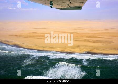 Flight over the Sceleton coast in Namibia where dunes of the Namib desert meet with Atlantic ocean, Africa Stock Photo