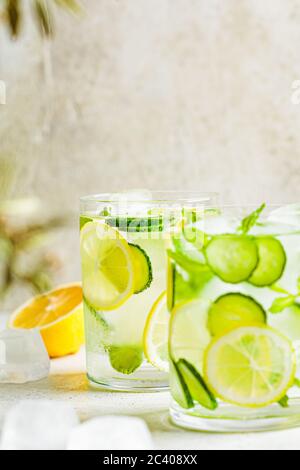 Detox sassy water with cucumber and lemon in glasses, light background. Healthy eating concept. Stock Photo