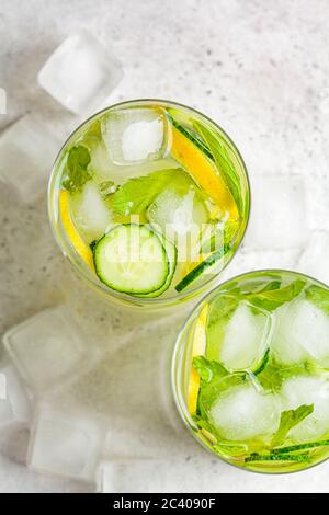 Detox sassy water with cucumber and lemon in glasses, light background. Healthy eating concept. Stock Photo