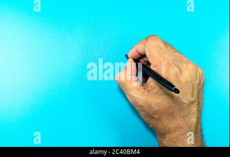 a man hand writing on a blue background with place for text Stock Photo