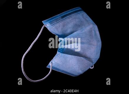 Simple blue standard surgical mask isolated on black Stock Photo