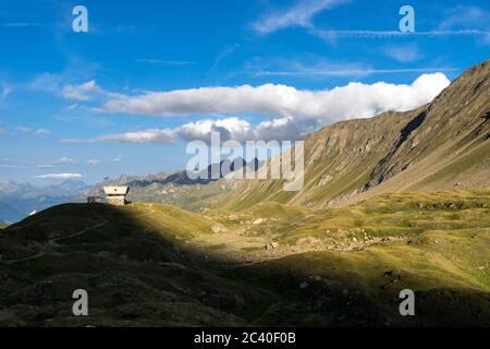 Die Capanna Corno-Gries CAS im Val Corno, Kanton Tessin, am Abend. Sicht Richtung Val Bedretto. Hinten von rechts Pizzo Grandinagia, Poncione di Valle Stock Photo